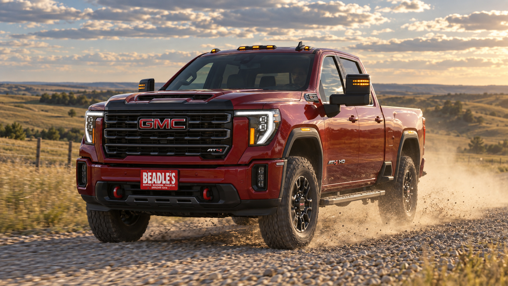2026 GMC Sierra 2500 HD AT4 in Volcanic Red on a gravel road near Mobridge, South Dakota