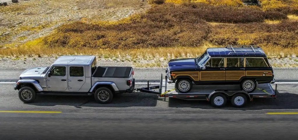 Jeep Gladiator pulling a vehicle on a trailer.