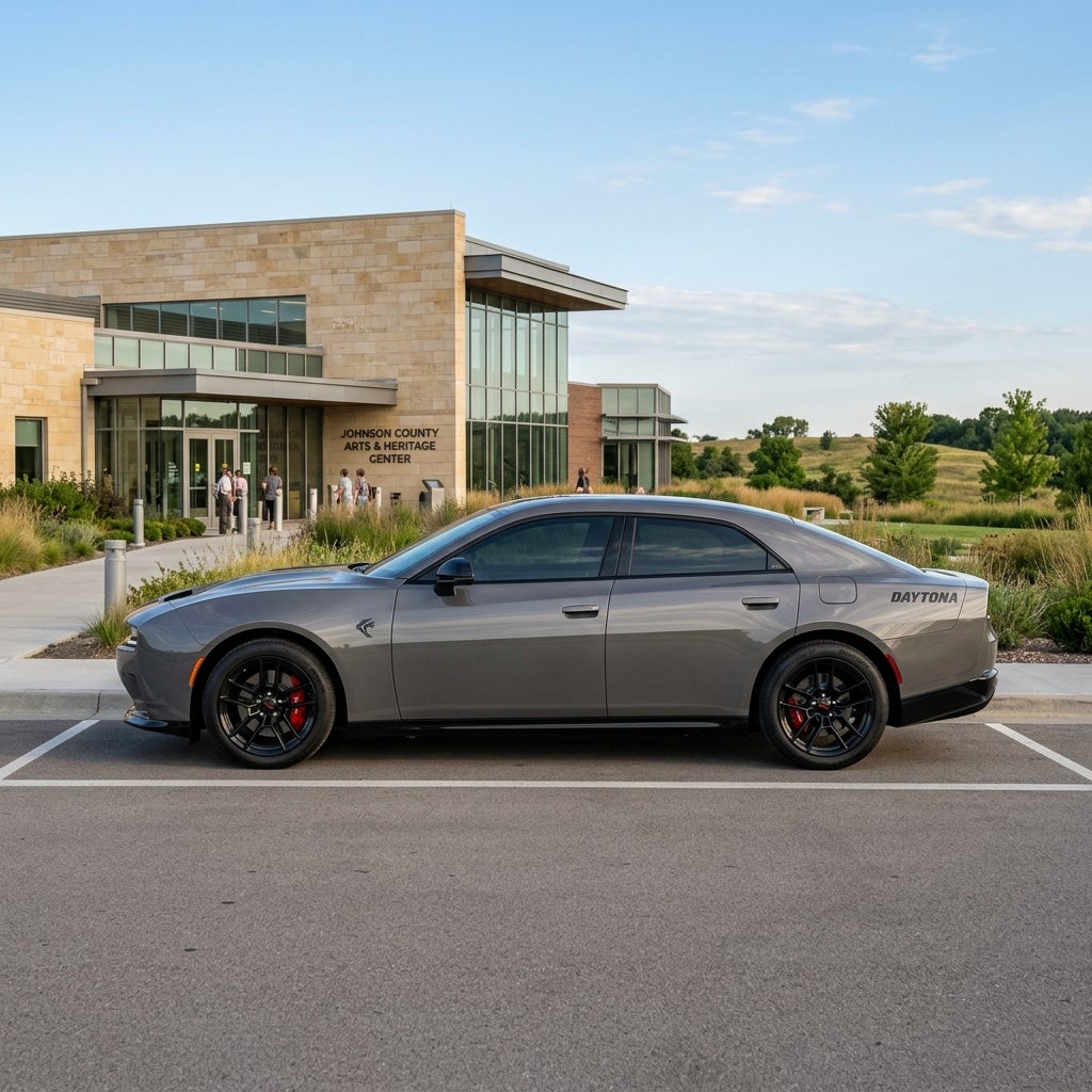 Profile view of a dark gray Dodge Charger Daytona parked in front of the Johnson County Arts & Heritage Center. (Representative image for illustration purposes only. Actual vehicle may vary based on trim and configuration.)