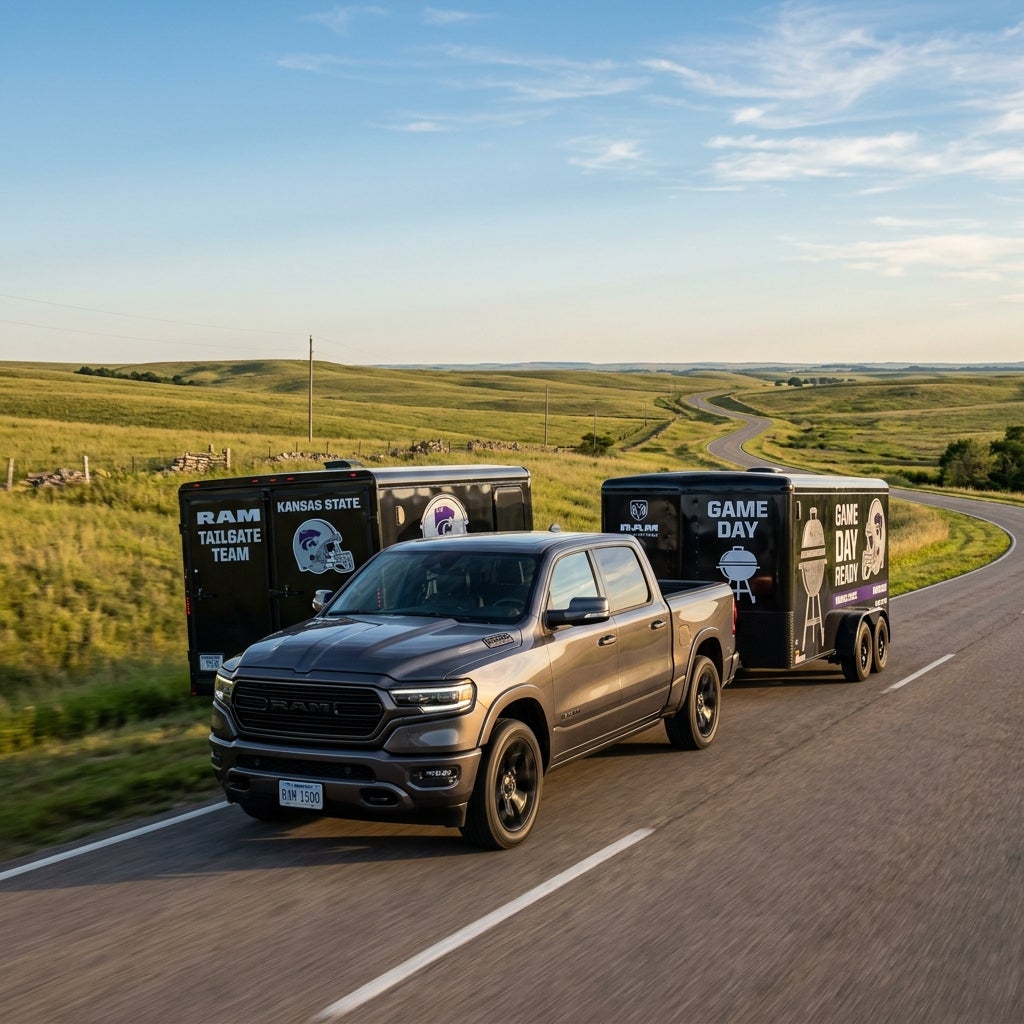 Dark grey Ram 1500 truck towing a black Kansas State Game Day tailgate trailer along a scenic country road. (Representative image for illustration purposes only. Actual vehicle may vary based on trim and configuration.)