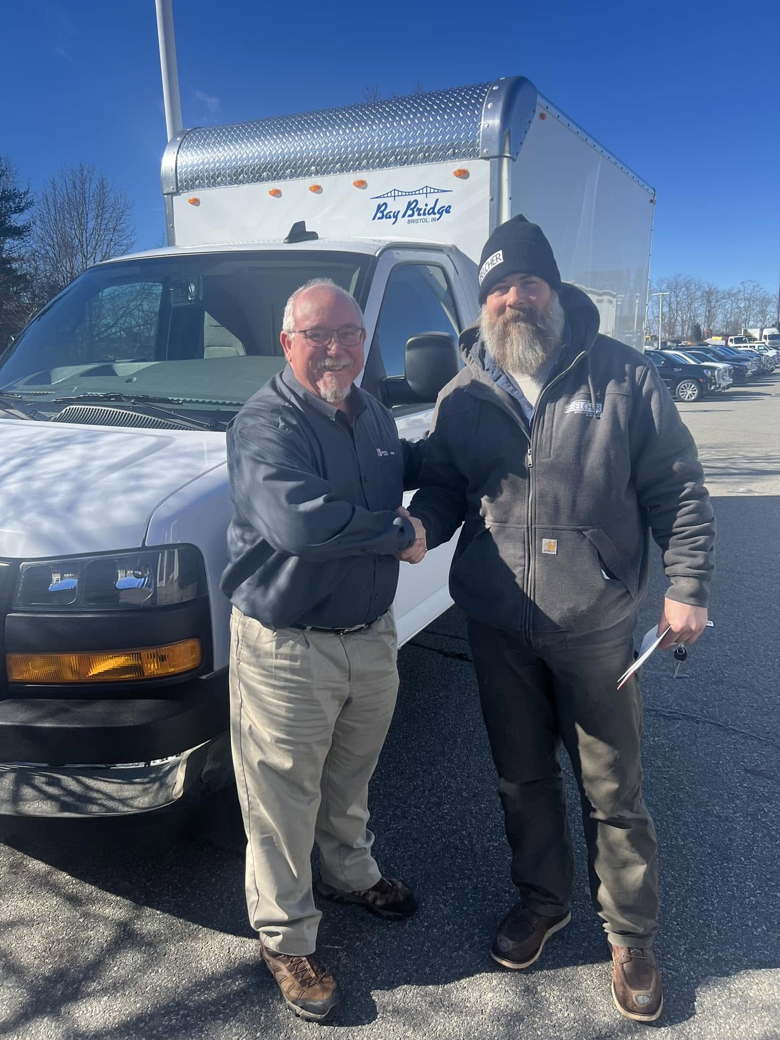 Customer delivery beside a GMC Savana with a box body
