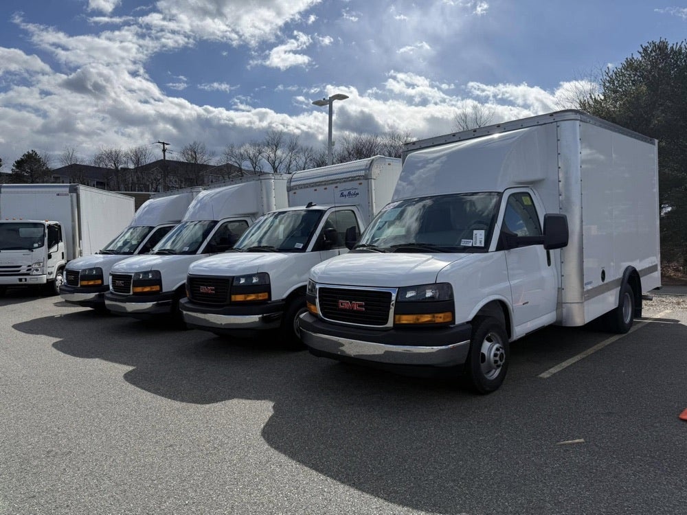 A row of GMC commercial vehicles with enclosed bodies