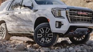 White GMC Yukon on a rocky road.