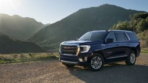 Dark blue GMC Buick surrounded by mountains.