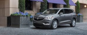 Silver 2021 Buick Enclave parked in front of a cobble street.