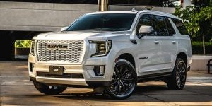 A white 2021 GMC Yukon Whiteout outside a parking garage.