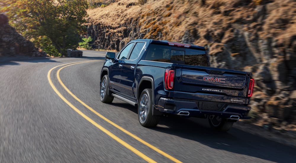 A blue 2025 GMC Sierra 1500 Denali is shown from the rear after leaving a GMC dealer.
