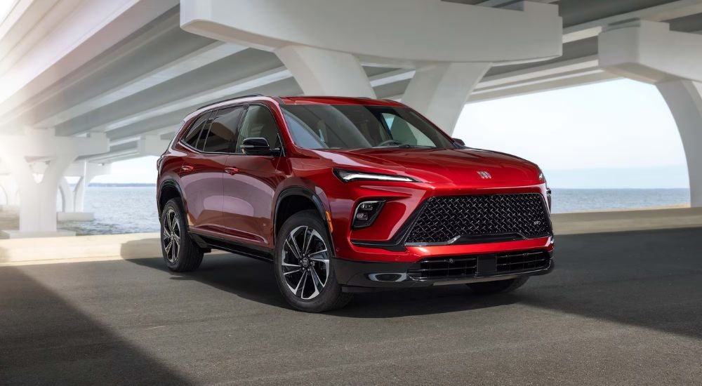 A red 2026 Buick Enclave ST shown parked under a bridge.