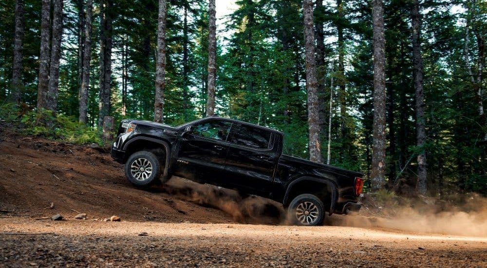 A black 2019 GMC Sierra 1500 AT4 off-roading on a dirt hill
