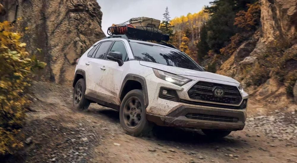 Red 2023 Toyota RAV4 TRD Off-Road driving off-road from a dealer with used cars for sale.