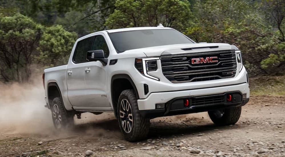A white 2026 GMC Sierra 1500 AT4 driving offroad.
