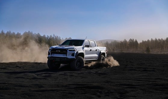 The 2024 Chevrolet Colorado ZR2 in Summit White, conquering a challenging rocky trail, showcasing its off-road dominance