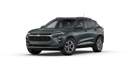 A sleek 2025 Chevrolet Trax LS in Cypress Gray, parked on a city street, showcasing its modern design and compact size, perfect for urban driving