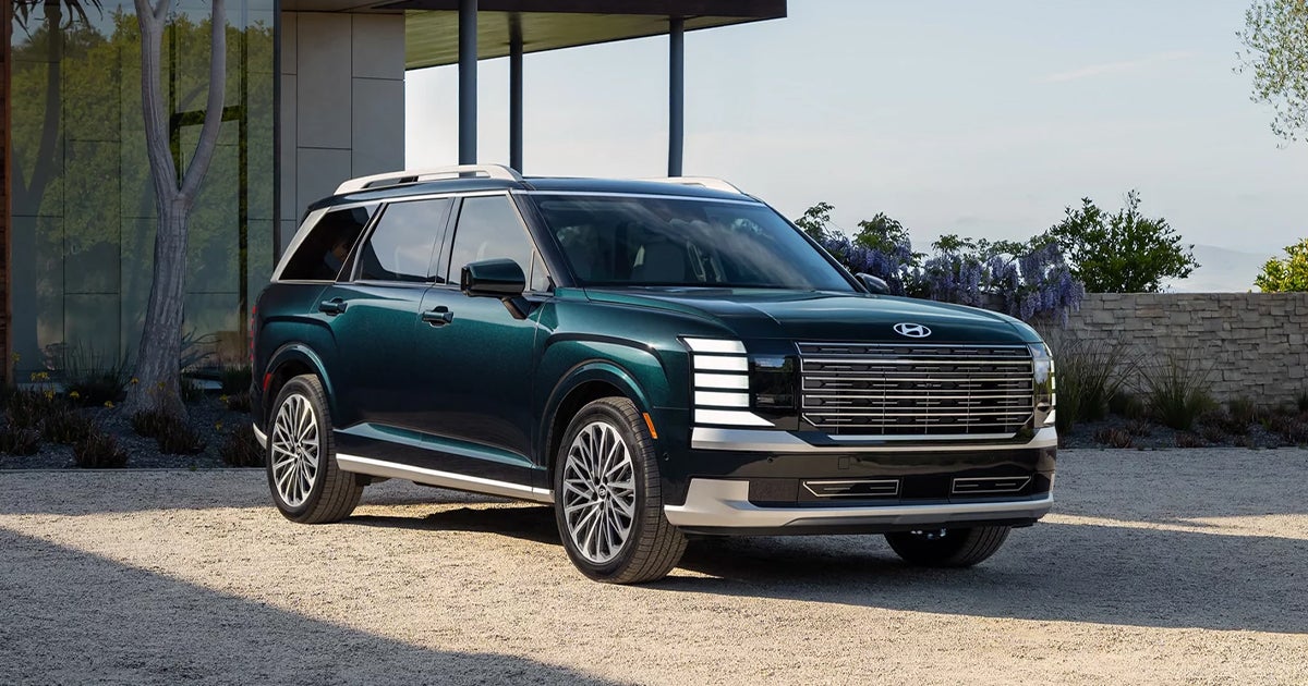 A Hyundai Palisade parked in front of a house.