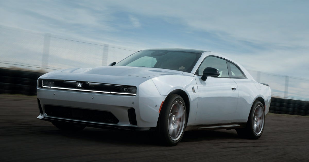 A Dodge Charger Daytona driving fast on a road.