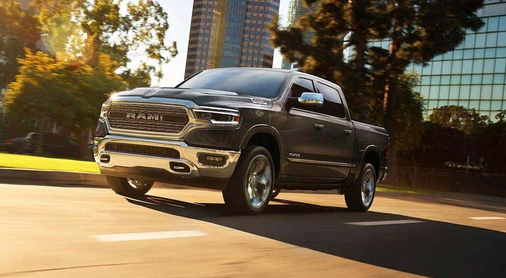 A grey 2022 Ram 1500 Tradesman for sale is shown driving on a city street.
