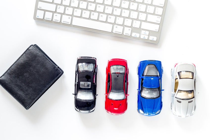 Buying car. Toy car and wallet near keyboard on white background top view