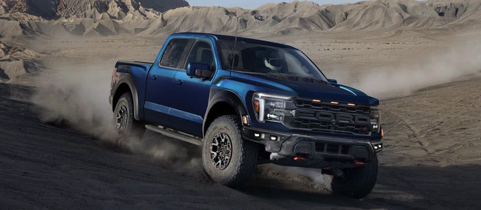 Blue Ford F-150 driving on dirt