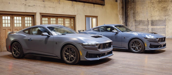 2 Ford Mustangs parked