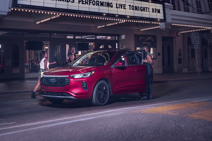Red Ford Escape with passengers getting into it