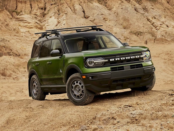 Green Ford Bronco Sport driving over rocks