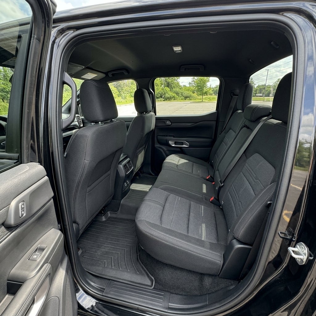 Spacious rear seating area of a modern black pickup truck with dark cloth seats and all-weather floor mats. (Representative image for illustration purposes only. Actual vehicle may vary based on trim and configuration.)