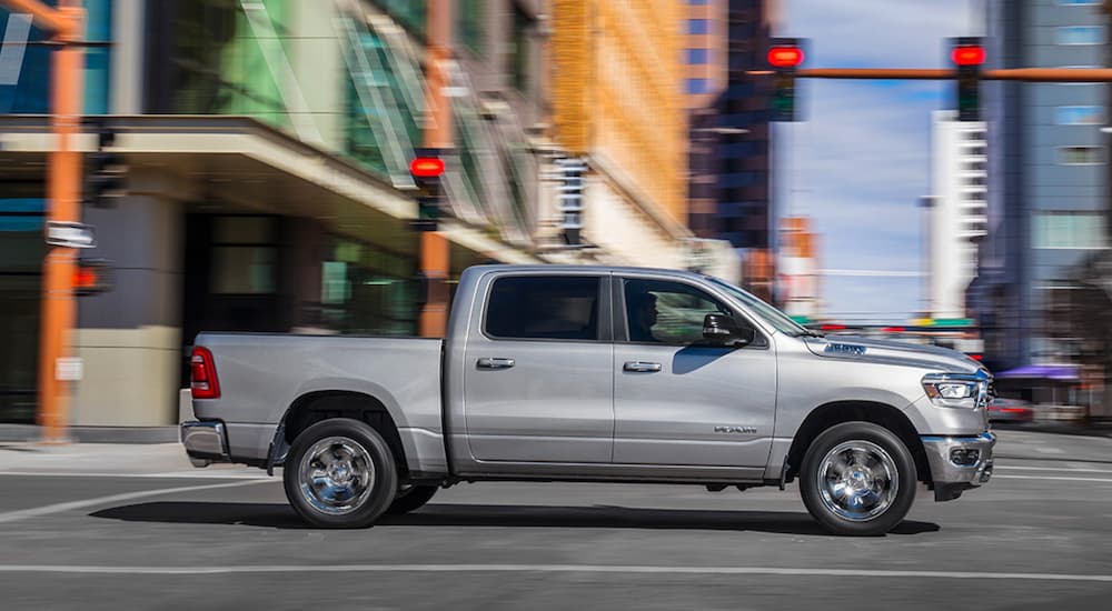 Side of a white 2019 Ram 1500 driving through an intersection.