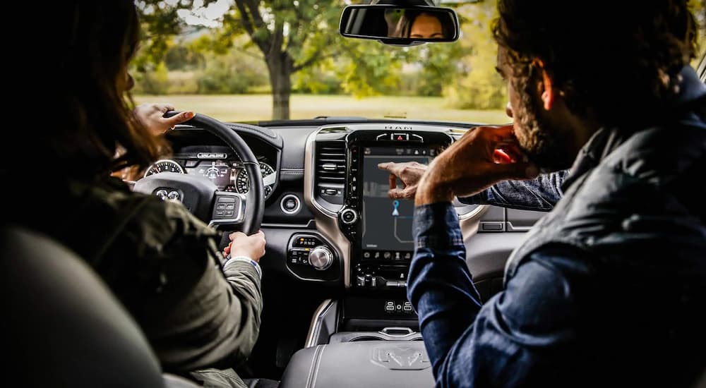 Two people sitting in a used 2022 Ram 2500 for sale on a test drive