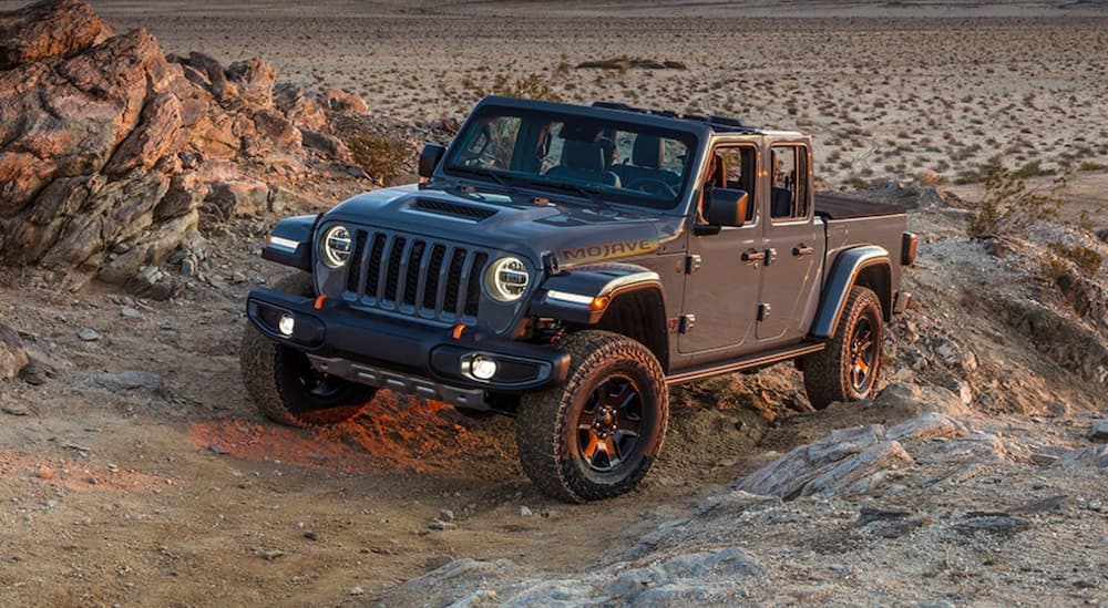 A grey 2021 Jeep Gladiator Mojave driving off-road in a desert.