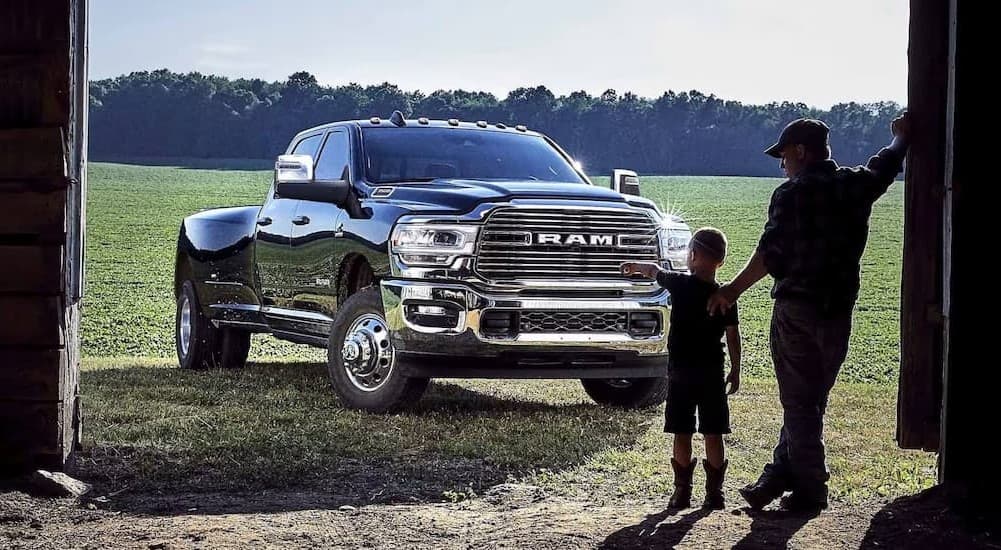 A black 2024 Ram 3500 parked near two people.