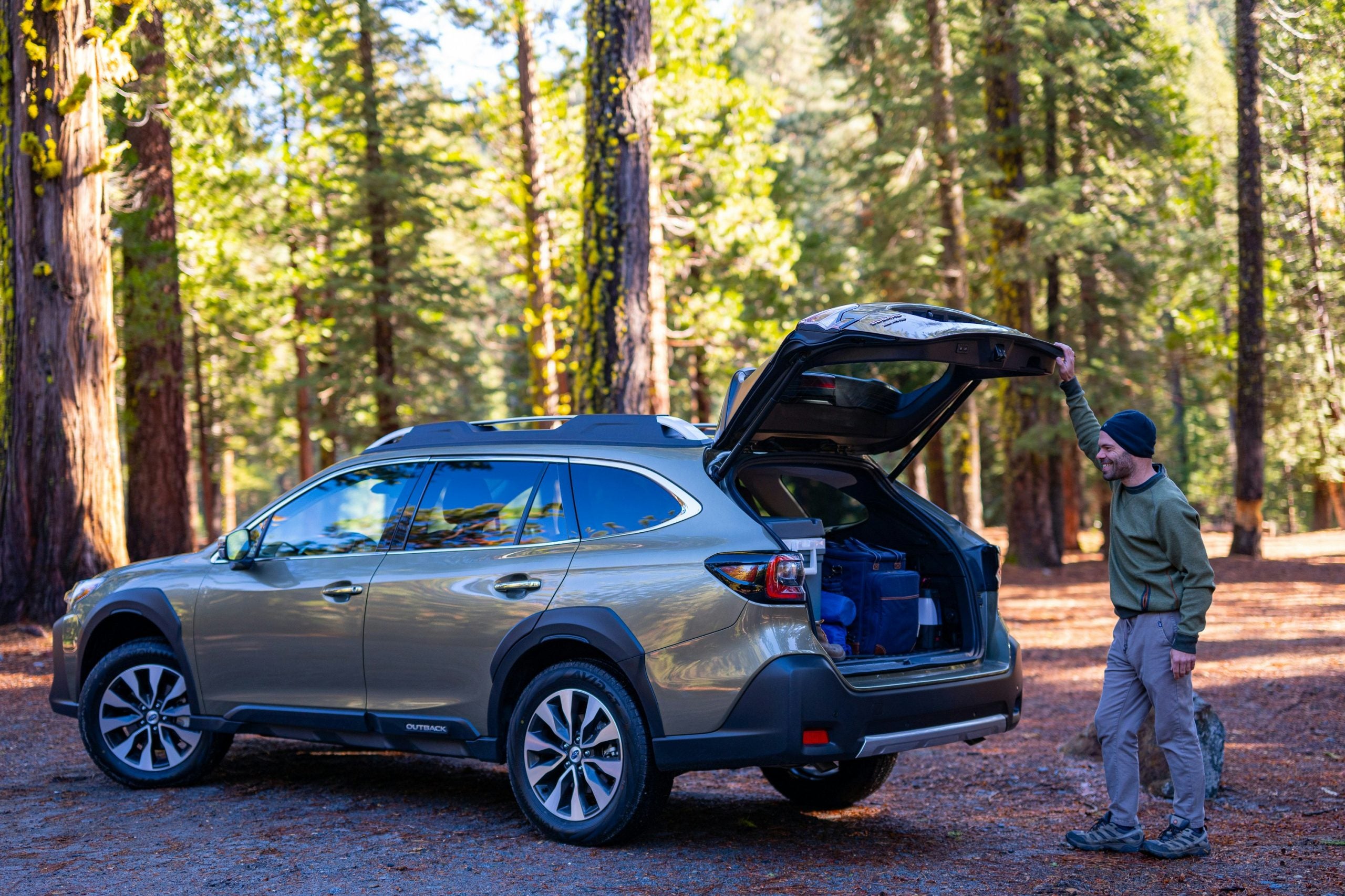 Camping gear loaded into the back of a 2025 Subaru Outback Touring XT SDL, with a man preparing to unload it.