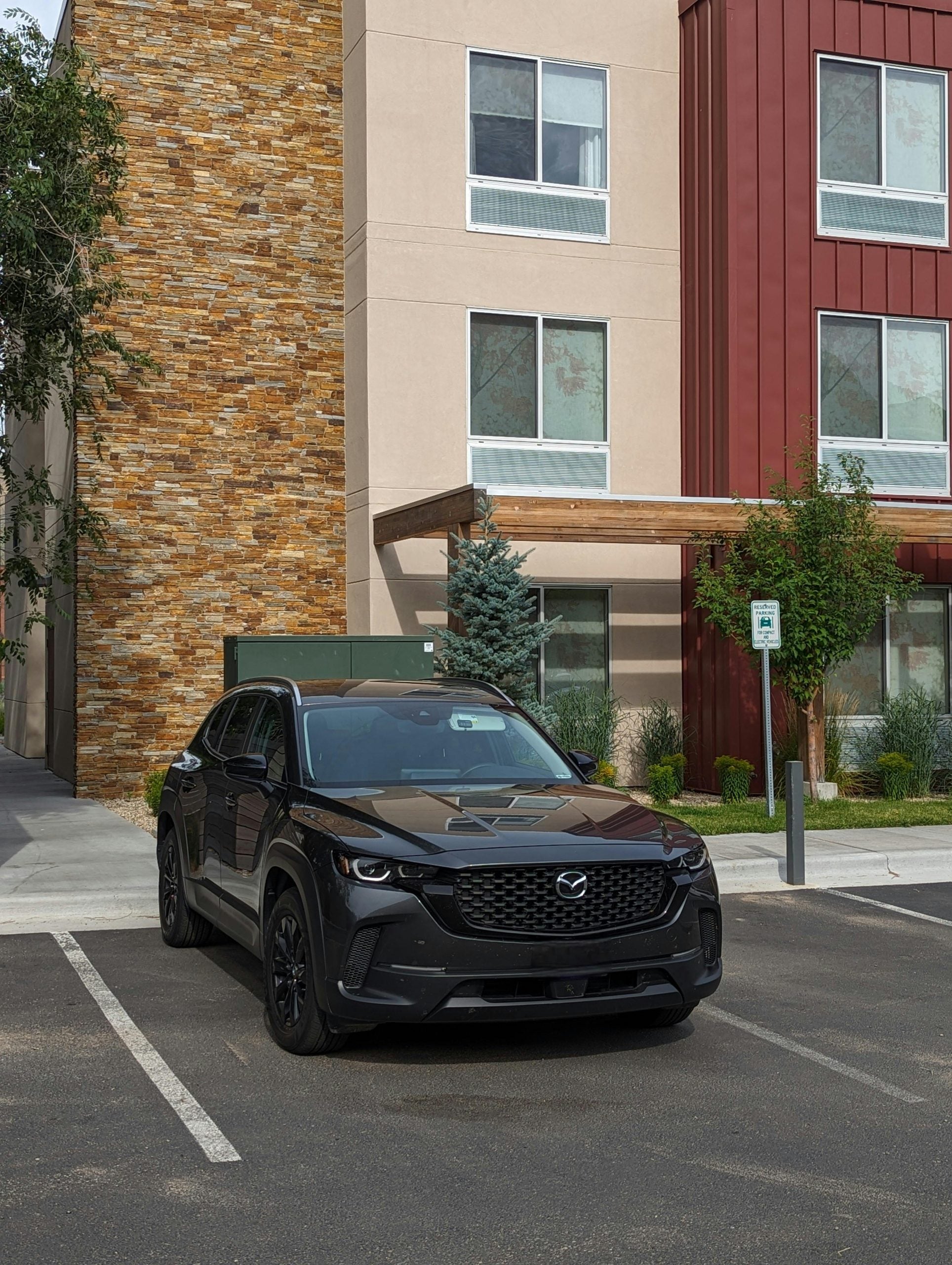 A Black Mazda CX-50 Parked in Front of a Building in a City
