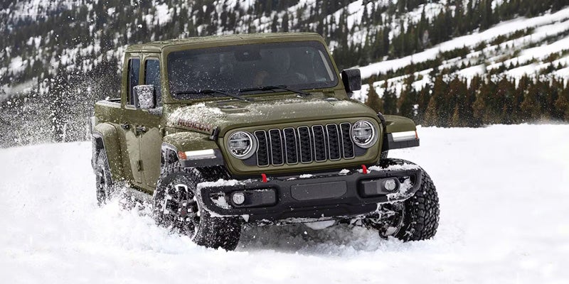 2026 Olive green Jeep Gladiator driving in the snow