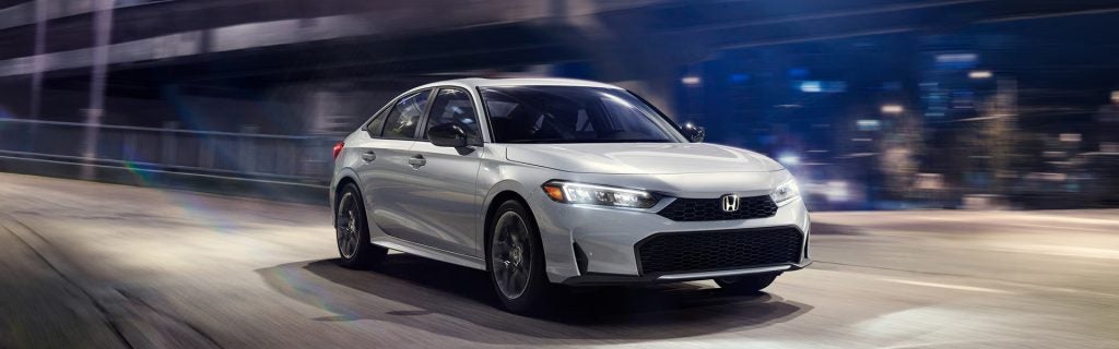 White Honda Civic Sedan Hybrid driving on city road
