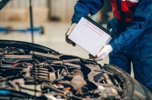 Mechanic replacing a battery in a Nissan car near Indianapolis, IN