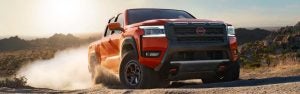 A Nissan Frontier truck driving through a desert landscape.