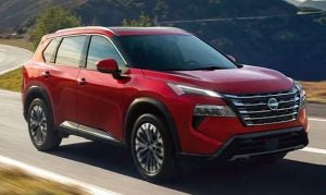 A red 2025 Nissan Rogue driving down an empty road near Indianapolis, Indiana