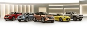Five Nissan vehicles, including SUVs, a sports car, and a pickup truck, displayed in a showroom setting.