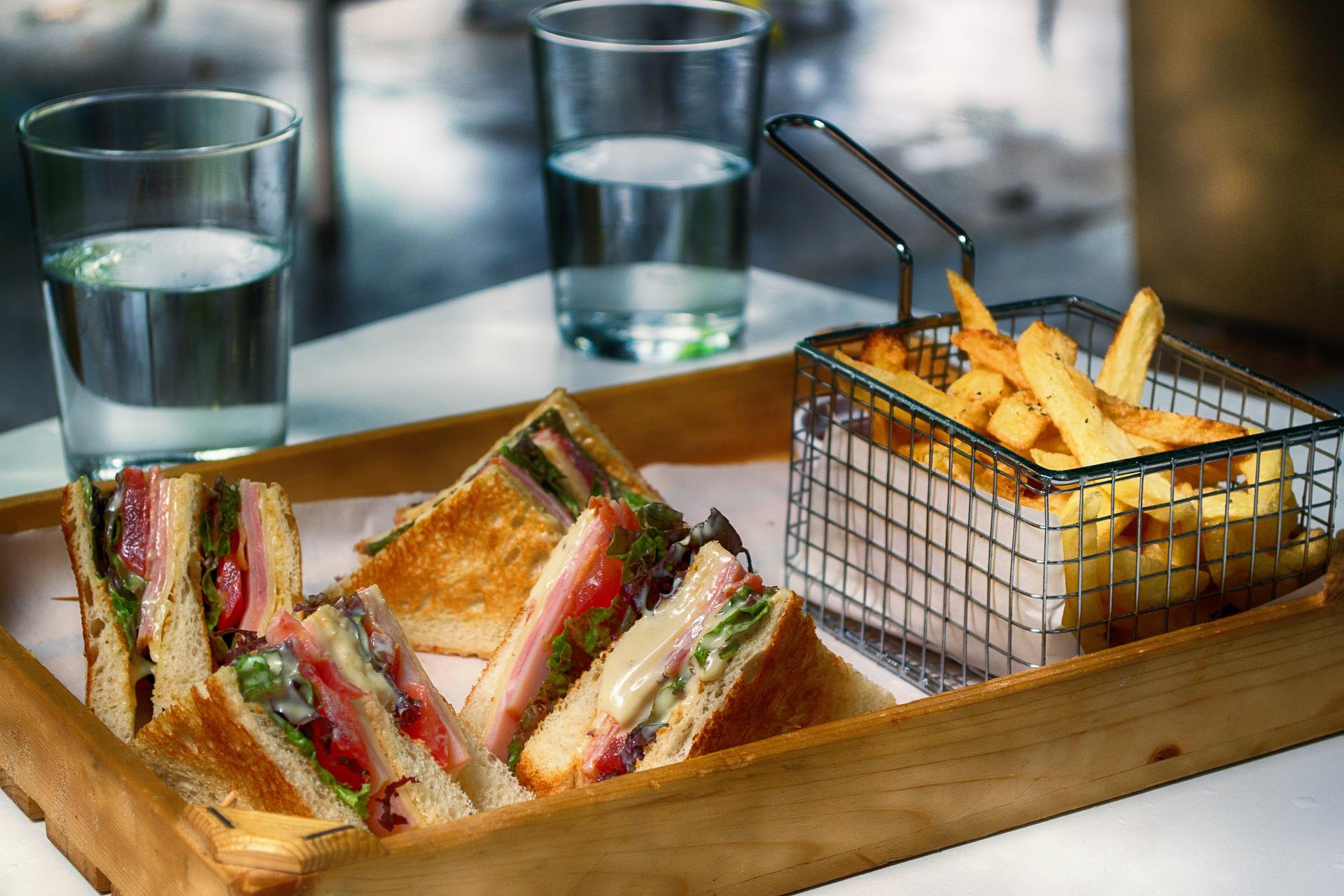 A club sandwich next to a side of fries