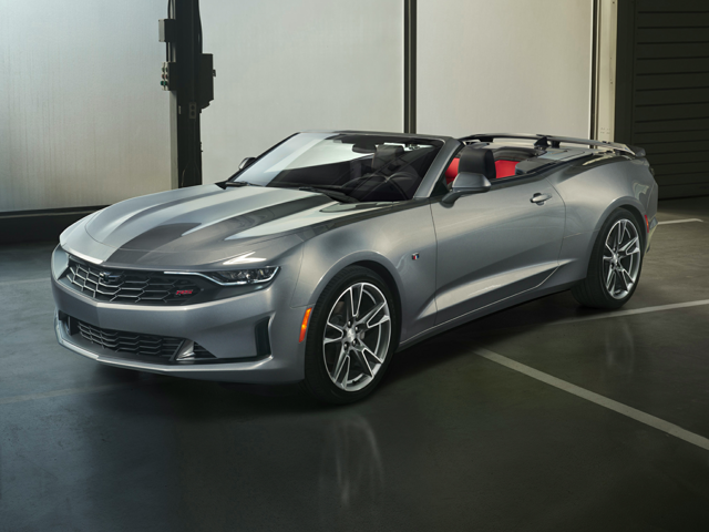 A silver Chevy Camaro convertible parked inside