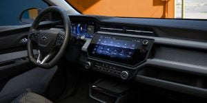 Chevrolet vehicle interior showing steering wheel and digital infotainment display on the dashboard.