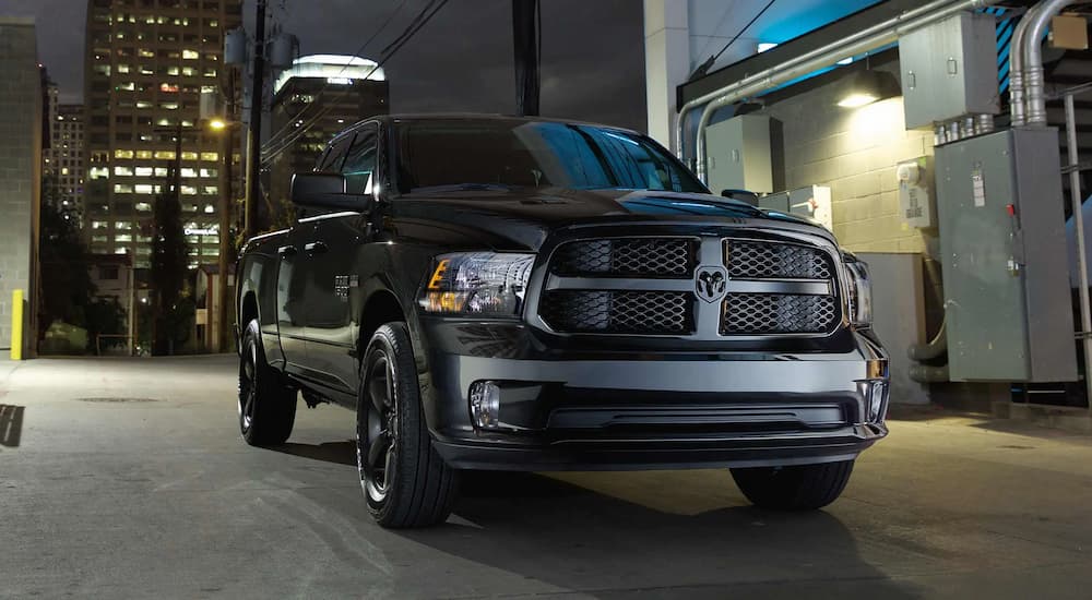A black 2021 Ram 1500 Classic, a popular used Ram for sale, on a city street.