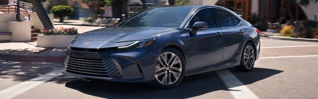 Toyota sedan driving on city street