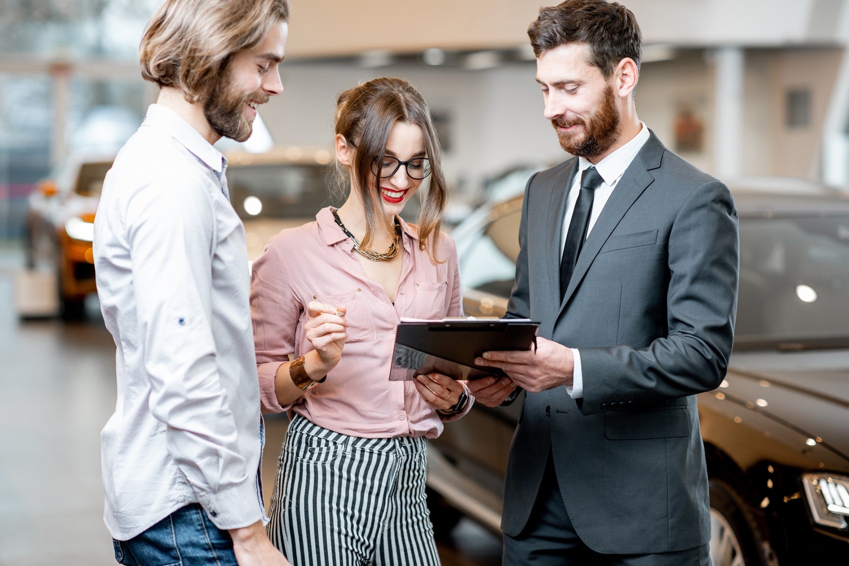 Ford Finance member reviewing paperwork with couple for their Ford Bronco lease