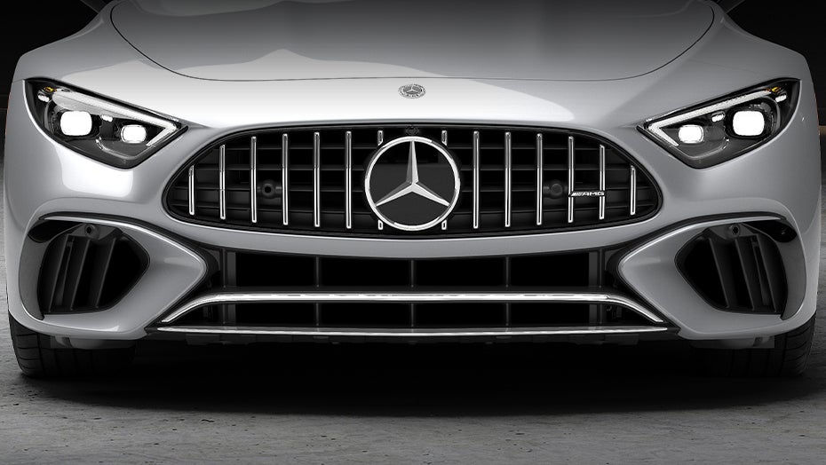 Interior view of a Mercedes-AMG® SL convertible with red leather seats, overlooking the city skyline and calm lake views.