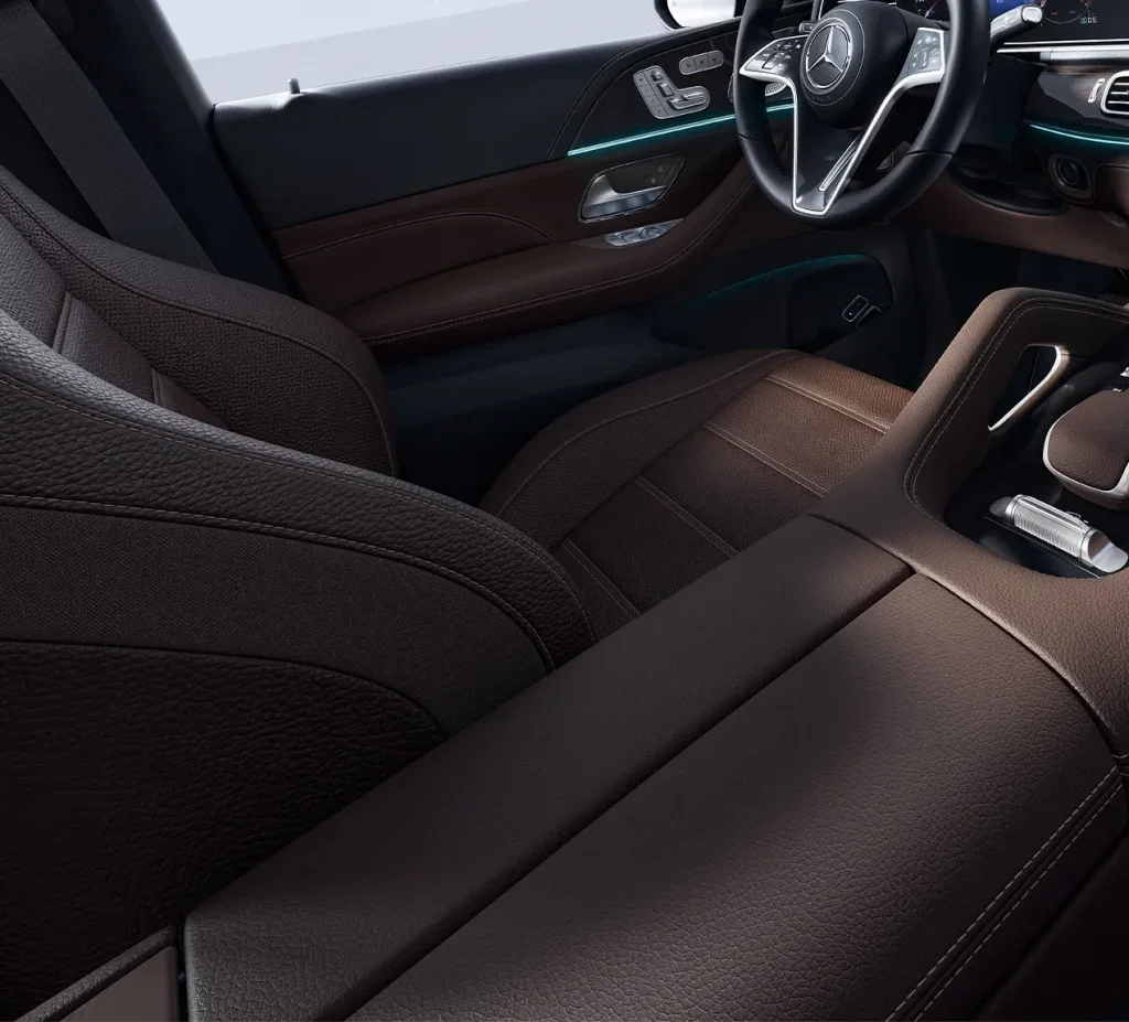 Interior shot of the 2026 Mercedes-Benz GLE front seats and dashboard, showcasing luxurious brown leather upholstery and modern cabin design built for long-lasting comfort.