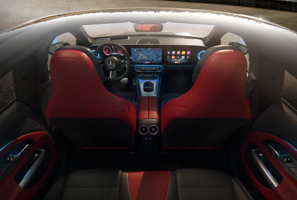 Interior of the all-electric 2026 Mercedes-Benz CLA with red seats, digital dashboard, MBUX screen, and premium luxury cabin design.
