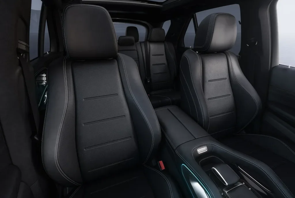 Front interior seating area of a Mercedes-Benz SUV with black leather seats and center console, highlighting comfort in the best Mercedes-Benz family cars available right now.