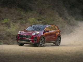 A red Kia Sportage driving