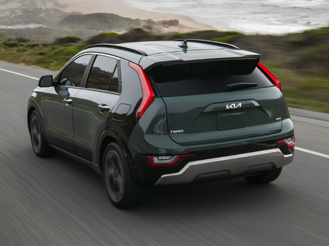 A green Kia Niro on the road